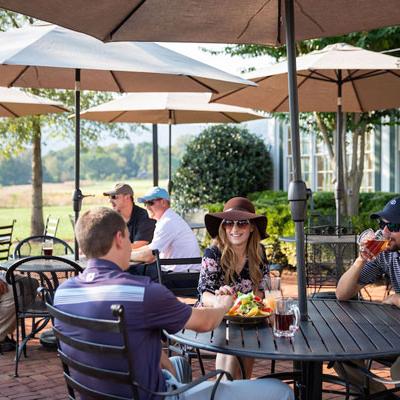 Breakfast patrons relax at umbrella-shaded tables on a patio in Crozet, VA